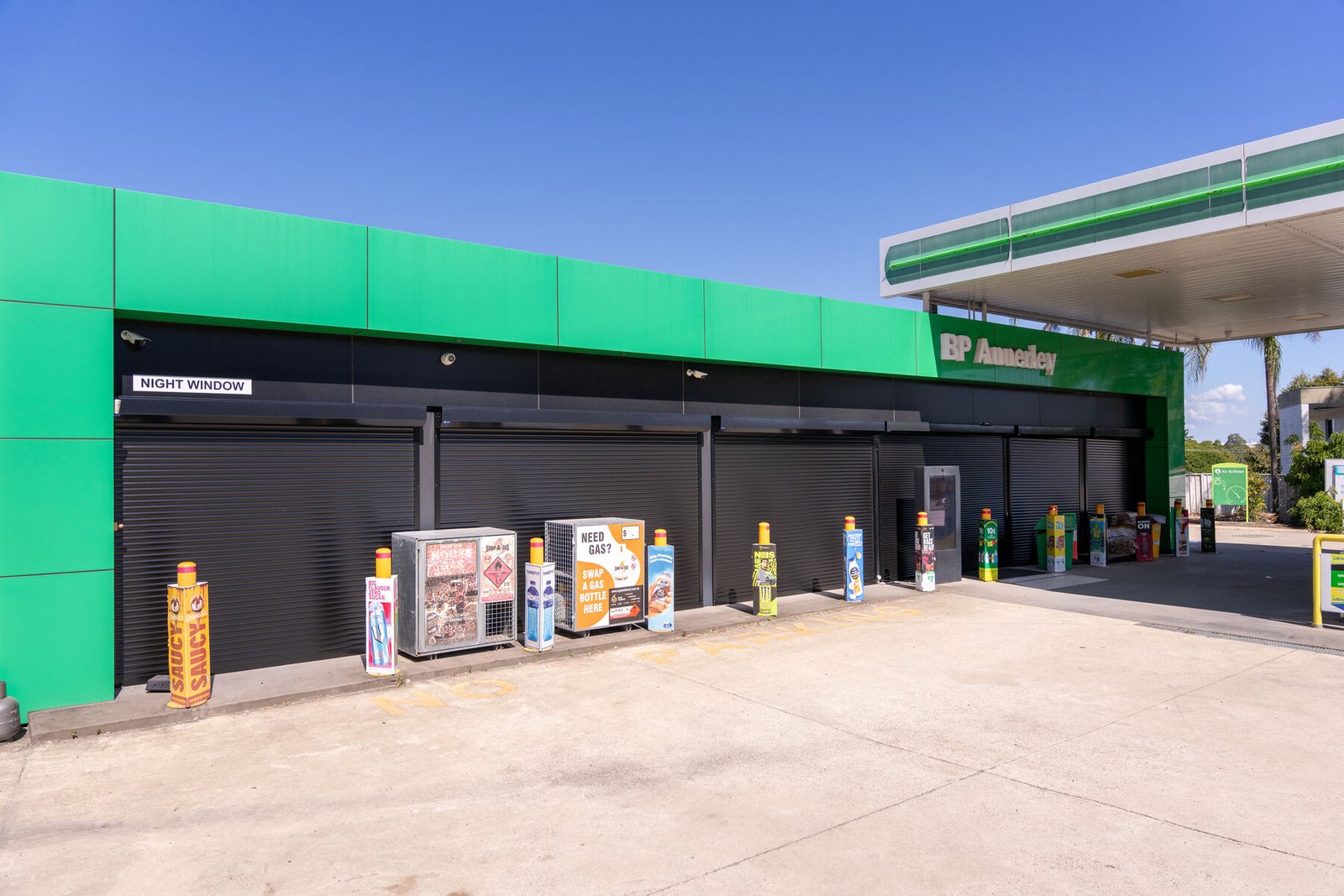 Retail brand exterior — BP service station forecourt under blue sky